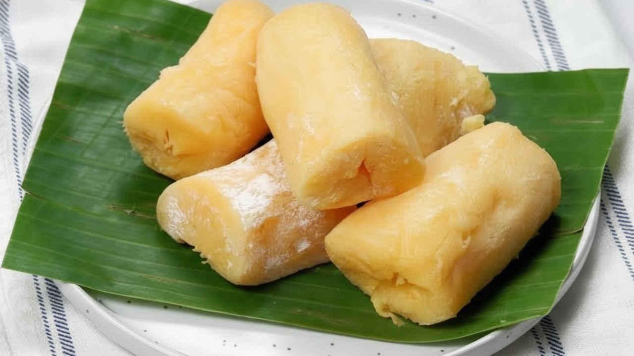 Tape singkong Samarinda dengan tekstur lembut dan warna kuning segar, disajikan di piring tradisional&mdash;visual yang memancing selera.
