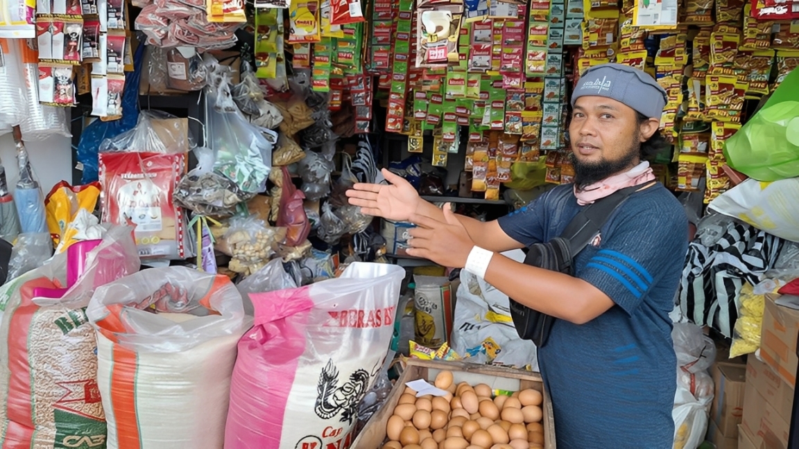Seorang pedagang memperlihatkan kondisi stok bahan pangan di tokonya di Penajam, Minggu (30 November 2025).