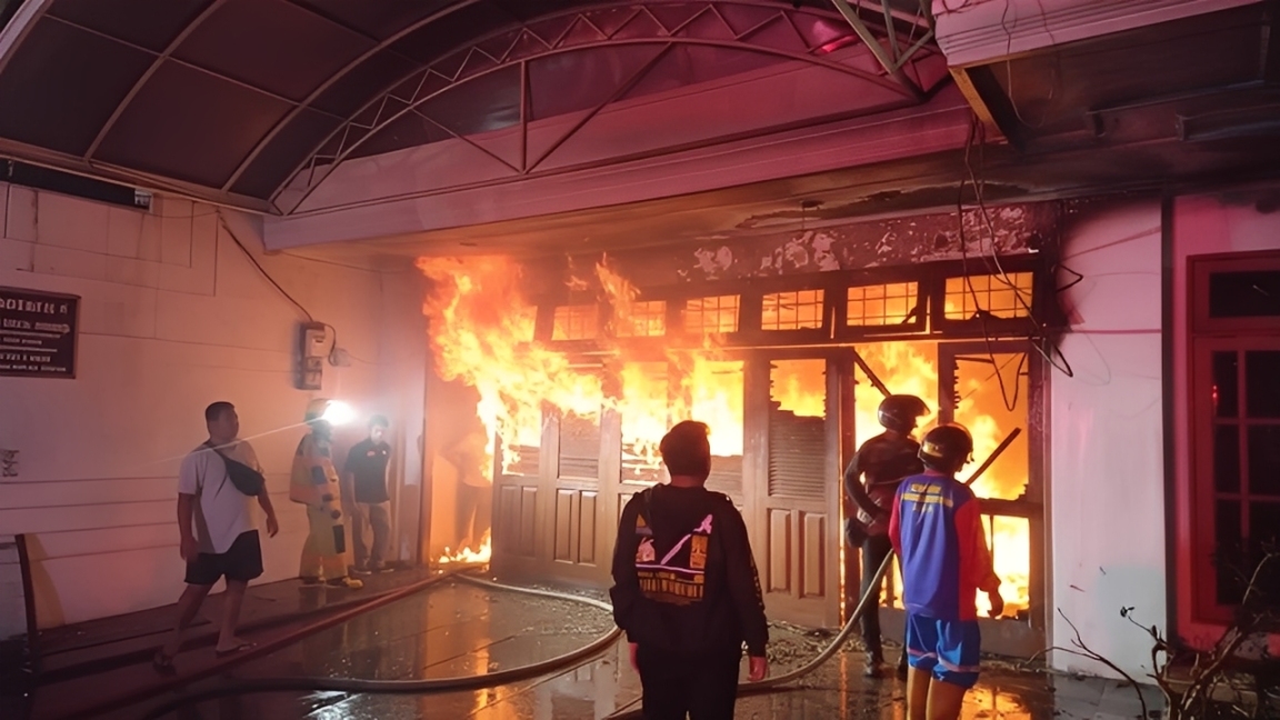 Petugas pemadam kebakaran berupaya memadamkan api yang membakar bagian garasi sebuah rumah di kawasan Jalan Berantas, Kelurahan Pelabuhan, Samarinda Kota, Sabtu malam (29 November 2025).