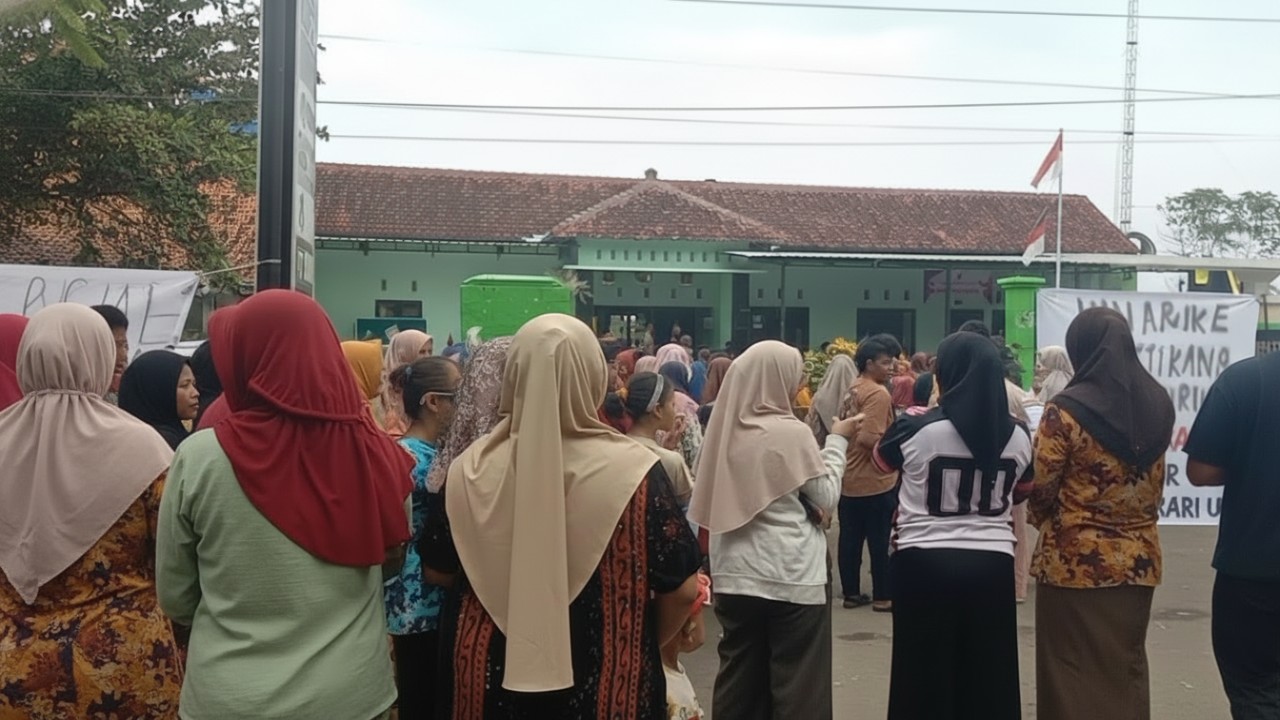 Warga Desa Padek berkumpul di depan balai desa dengan spanduk tuntutan
