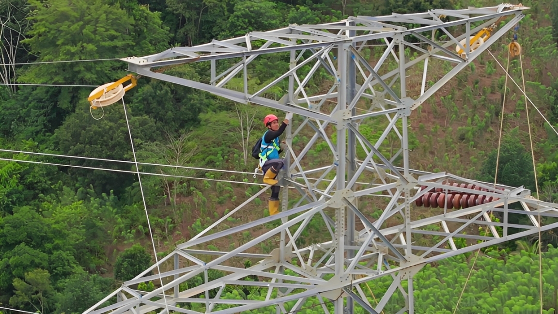 Pegawai PLN memeriksa tower dan kabel transmisi untuk memastikan pasokan listrik aman dan andal.
