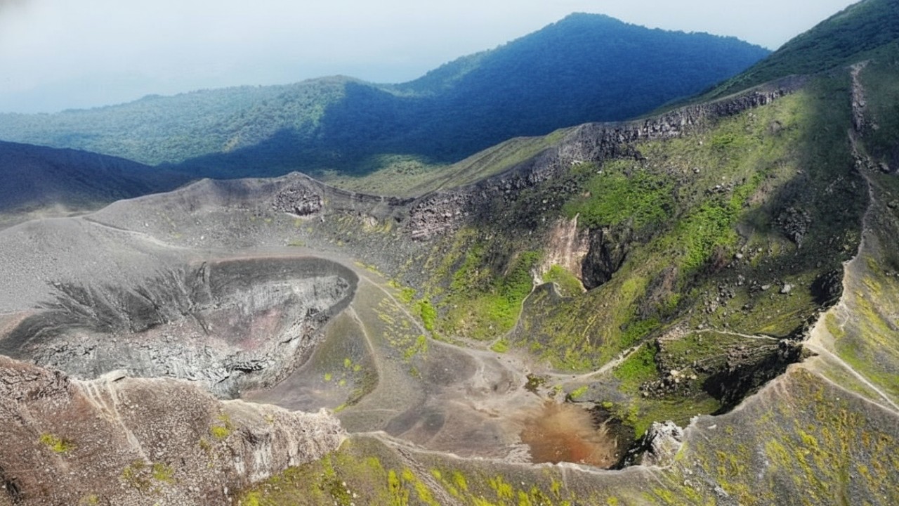Panorama kawah besar Bukit Kaba dengan latar bukit hijau yang memikat, menghadirkan suasana pegunungan yang dramatis dan fotogenik.
