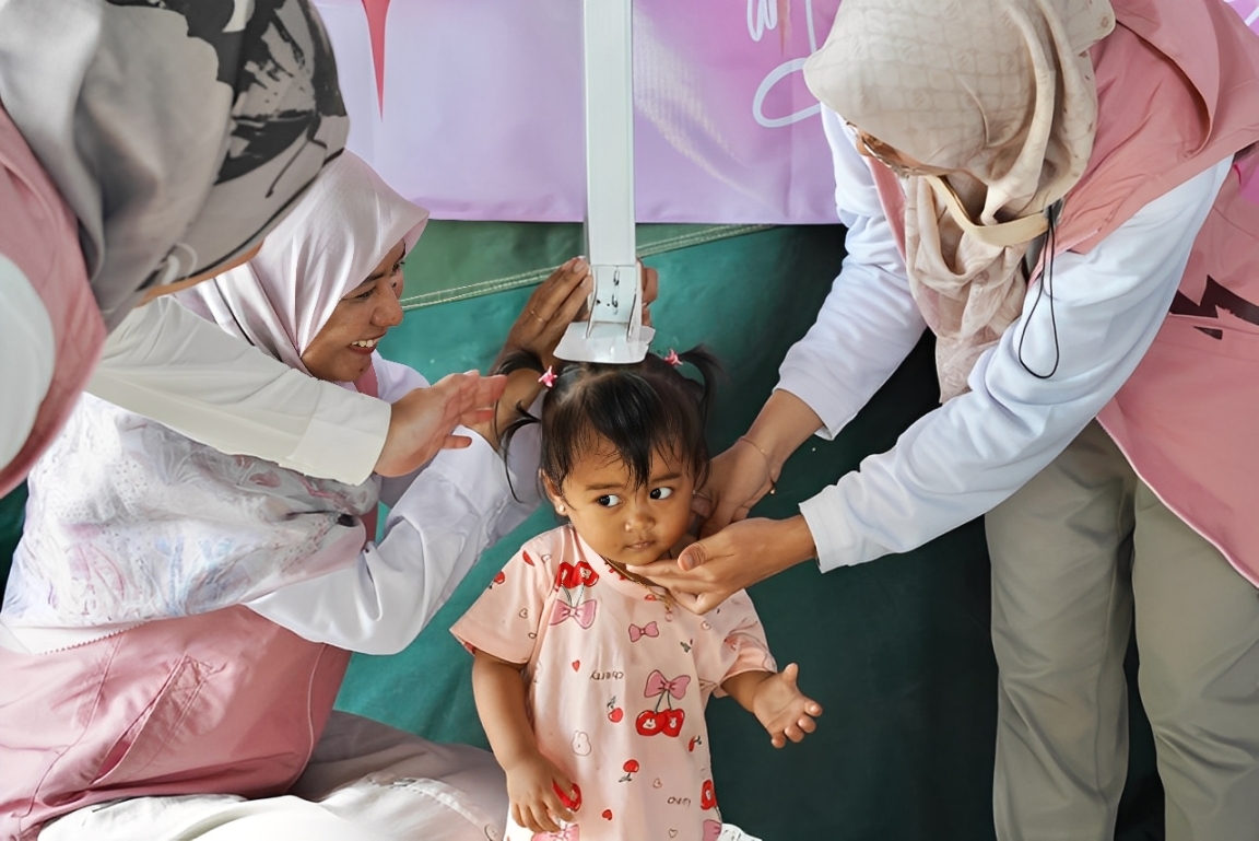 Srikandi PLN UIP KLT mengukur berat badan, tinggi badan, dan lingkar kepala salah satu anak penerima manfaat, Kamis (27 November 2025).