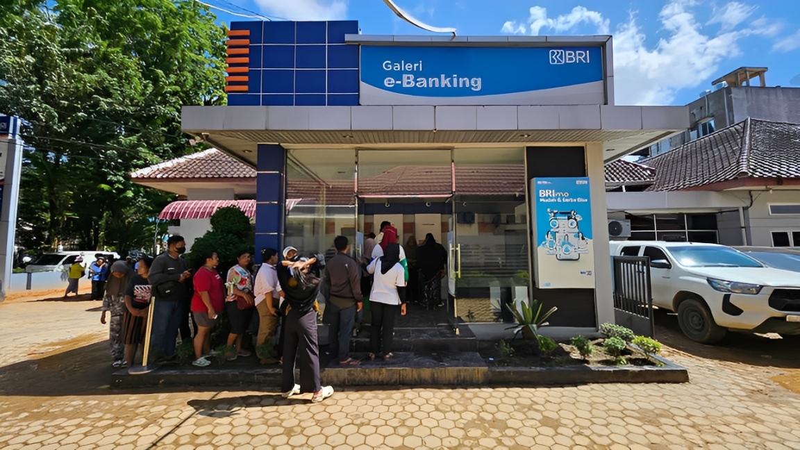 Warga terlihat mengantre di Galeri e-Banking BRI untuk melakukan transaksi perbankan.