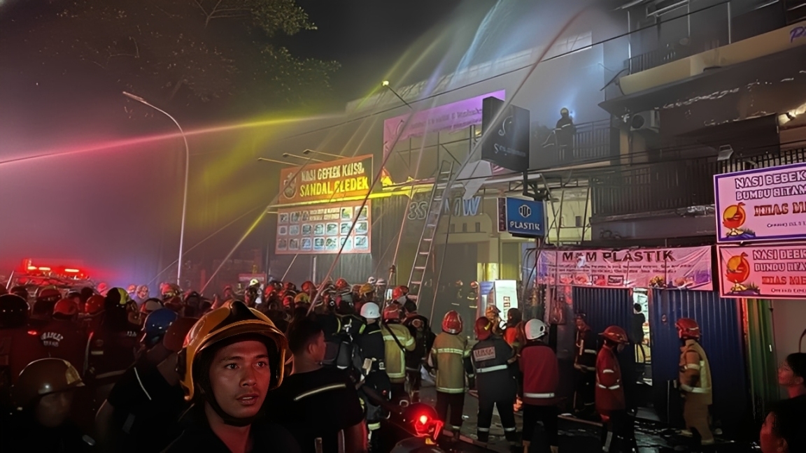 Petugas damkar berusaha memadamkan kebakaran di salah satu ruko di Samarinda, Minggu (7 Desember 2025).