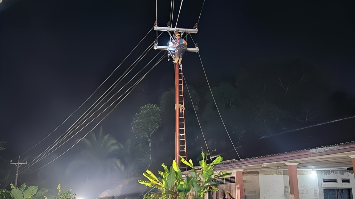 Petugas PLN memperbaiki jaringan distribusi tegangan menengah yang terdampak bencana di Aceh.