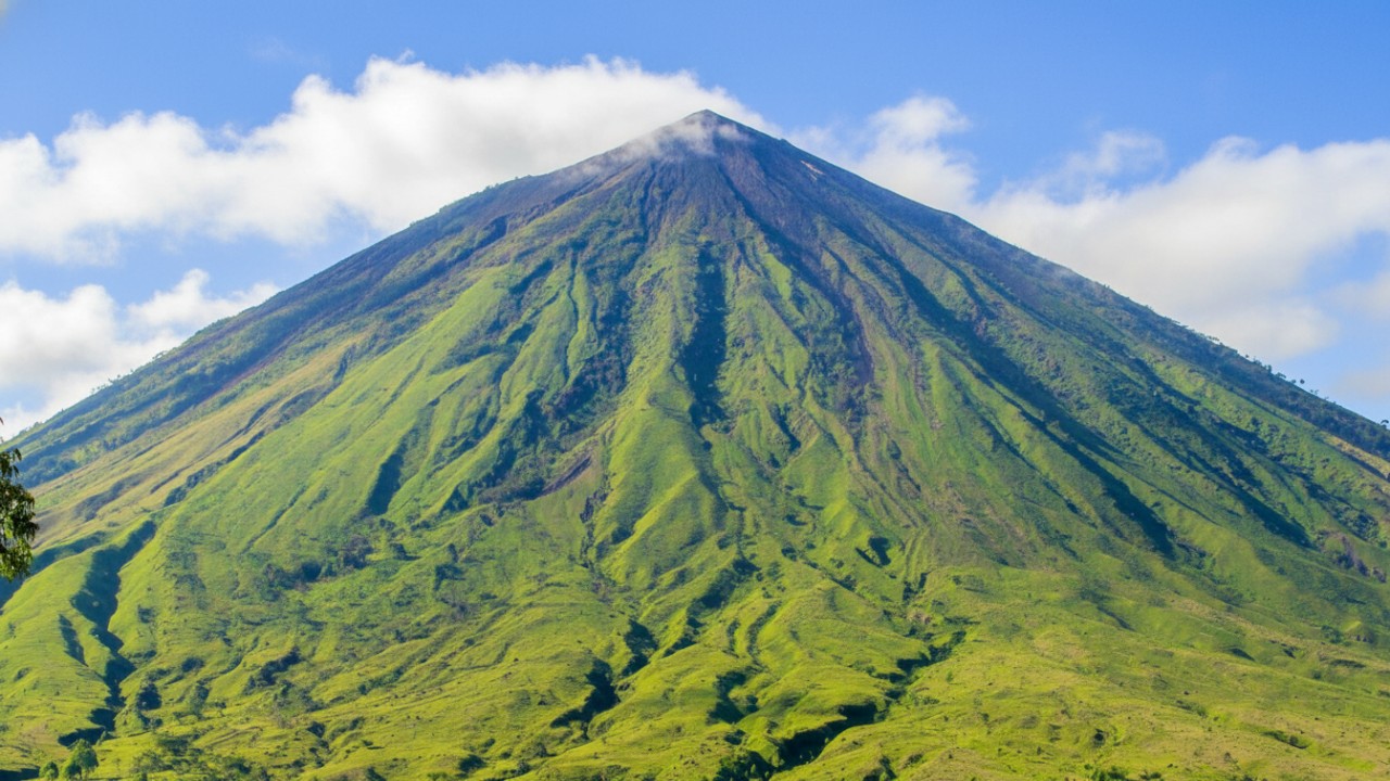 Gunung Inerie &ndash; siluet kerucut megah dengan cahaya pagi sebagai hook visual yang dramatis.