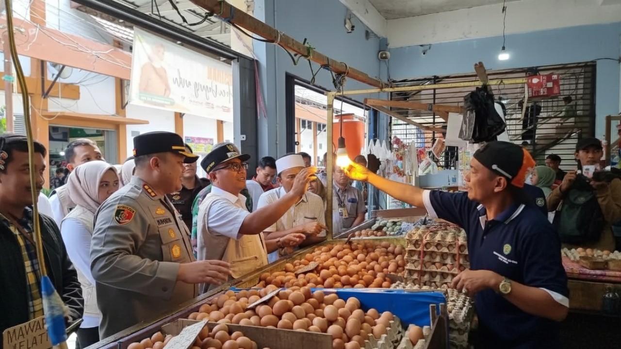 Pedagang di Pasar Merdeka menata telur dan ikan laut yang harganya naik jelang Natal, menggambarkan dinamika pasar akhir tahun.