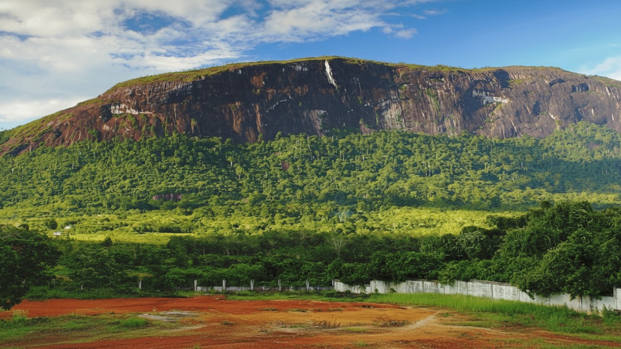 Bukit Kelam megah diselimuti cahaya pagi, visual kuat yang menonjolkan skala batu monolit dan lanskap hijau.