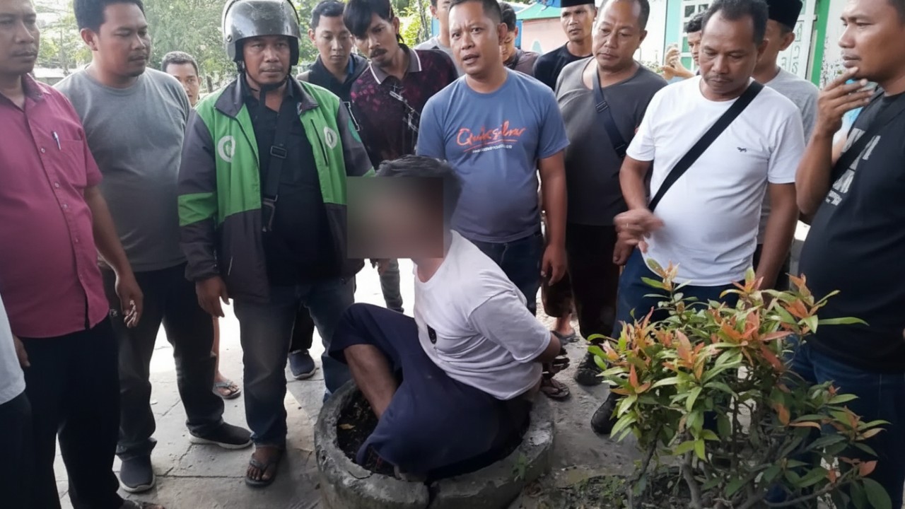 Warga terlihat mengamankan tersangka pencurian handphone di salah satu Alfamart di Balikpapan, Sabtu (13 Desember 2025).