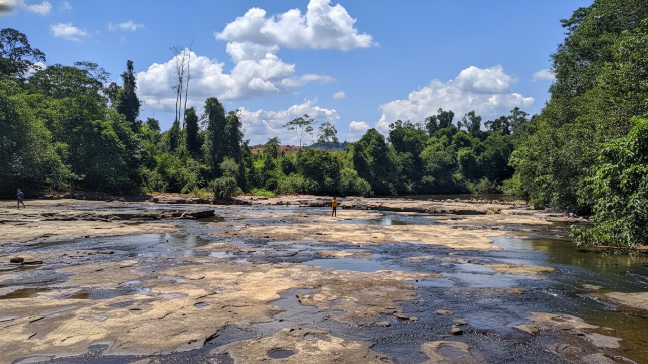 Hamparan batu pipih dan aliran sungai jernih Keham Batu Lepek di Penghuluan, suasana alami yang menenangkan.
