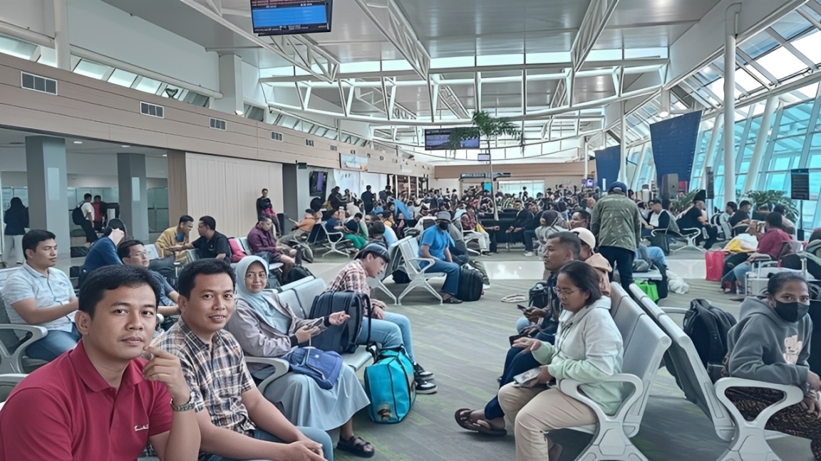 Penumpang menunggu jadwal keberangkatan di ruang tunggu bandara.