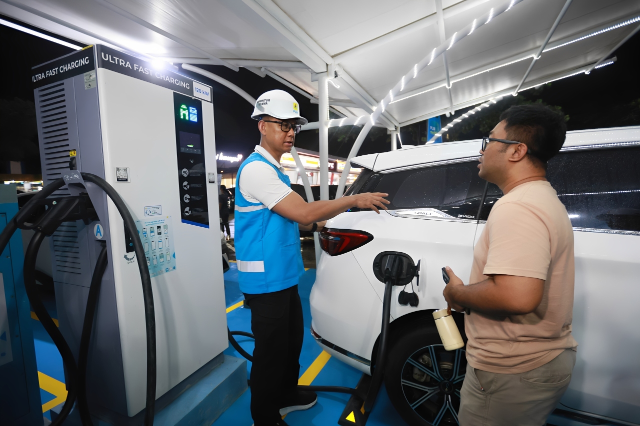 Direktur Utama PLN, Darmawan Prasodjo (kiri), meninjau layanan SPKLU kepada pengguna di Rest Area 228 A Cirebon, Selasa tengah malam (23 Desember 2025).