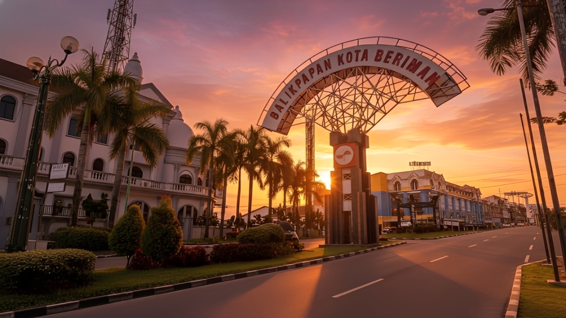 Suasana sore hari di Simpang Empat Balikpapan Baru dengan ikon Balikpapan Kota Beriman di tengah ruas jalan.