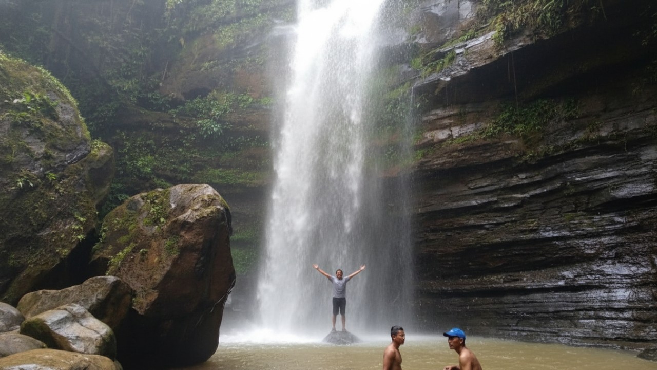 Air Terjun Tembinus dengan aliran air jernih di tengah hutan tropis Penajam Paser Utara yang sejuk dan alami.