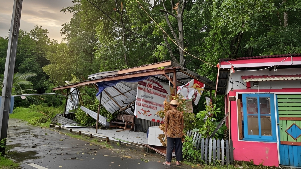 Warga melihat bangunan yang rusak akibat pohon tumbang di Balikpapan.