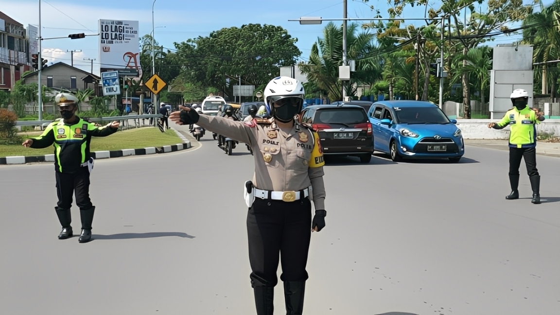 Petugas melakukan rekayasa lalu lintas dengan mengatur arus kendaraan menuju Pantai Manggar, Balikpapan, saat libur akhir tahun 2025.