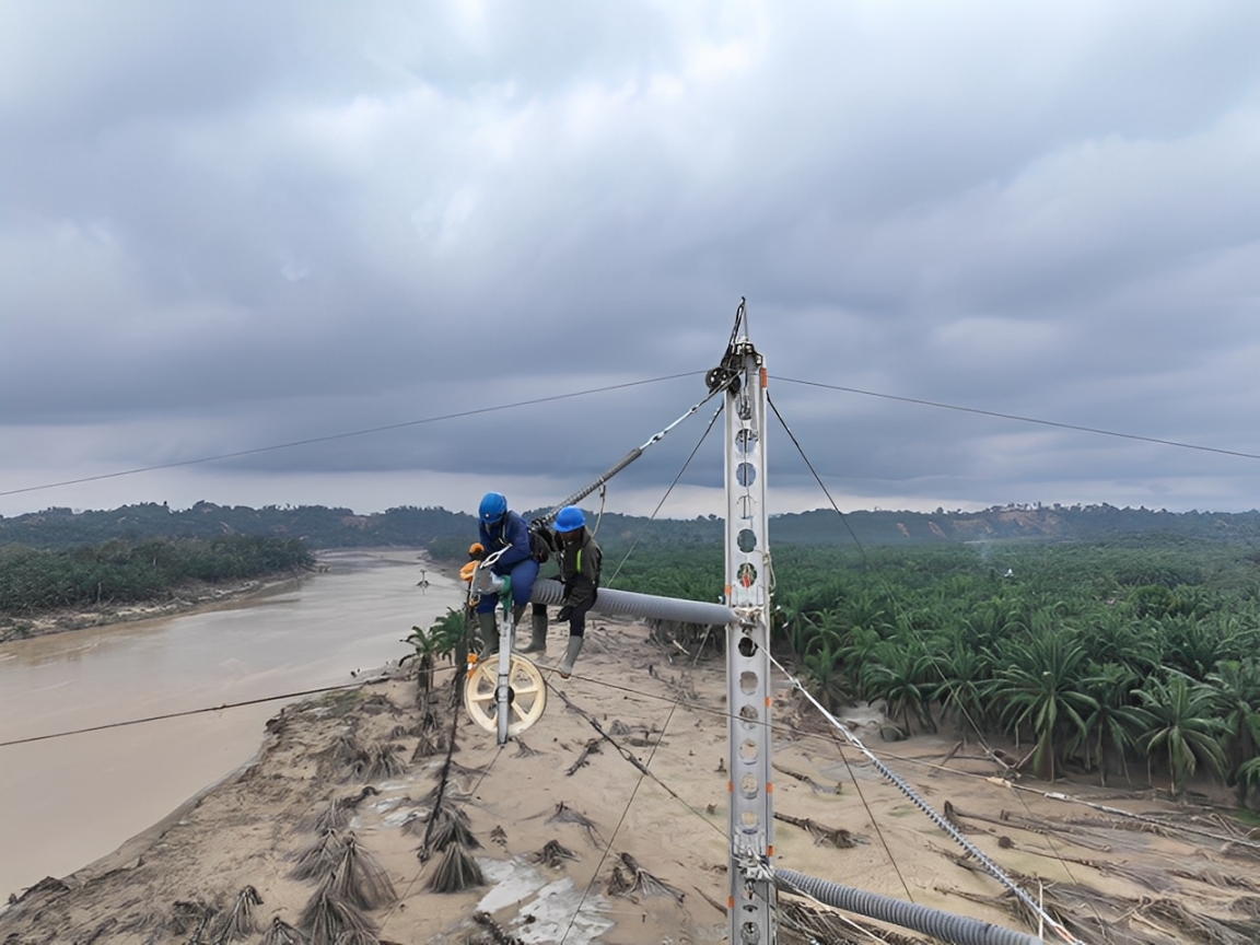 Petugas PLN mendirikan tower transmisi Pangkalan Brandan-Langsa jalur 2 di tengah medan berlumpur.