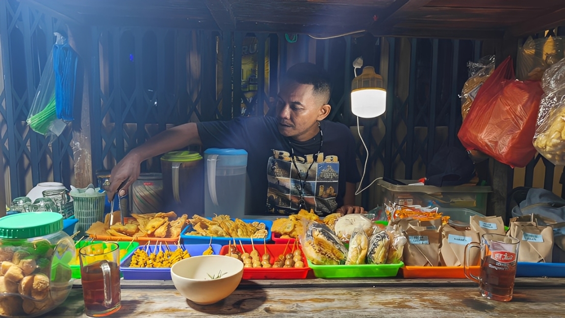Heddy Pamungkas, pemilik Angkringan Moses, menata dagangan di lapak usahanya.