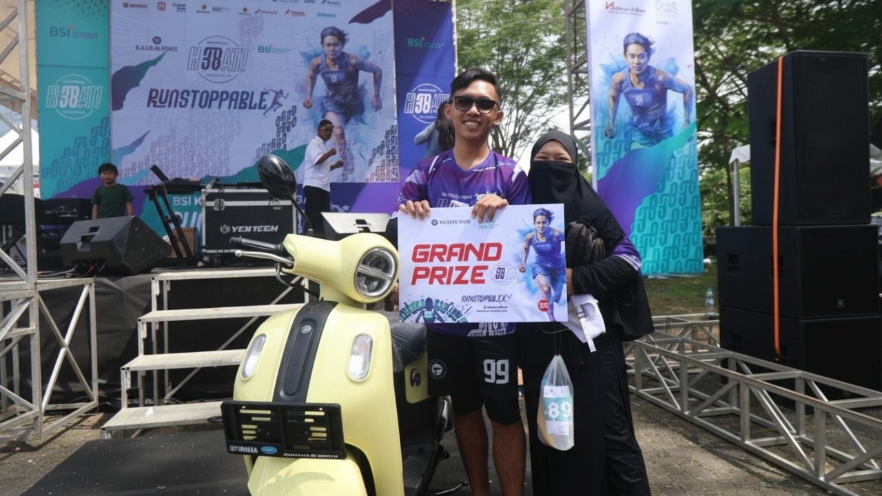 Muhammad Ridho tersenyum membawa hadiah sepeda motor.