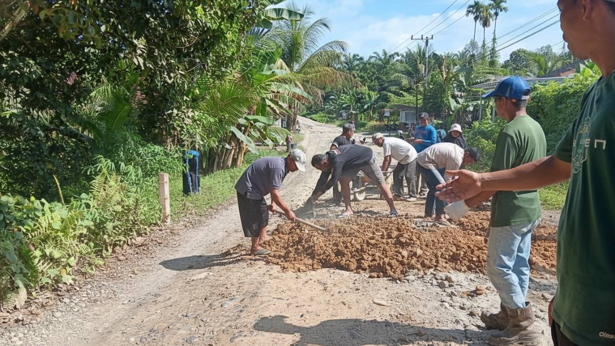 Aksi gotong royong warga Desa Legai menambal jalan rusak sebagai bentuk protes damai.