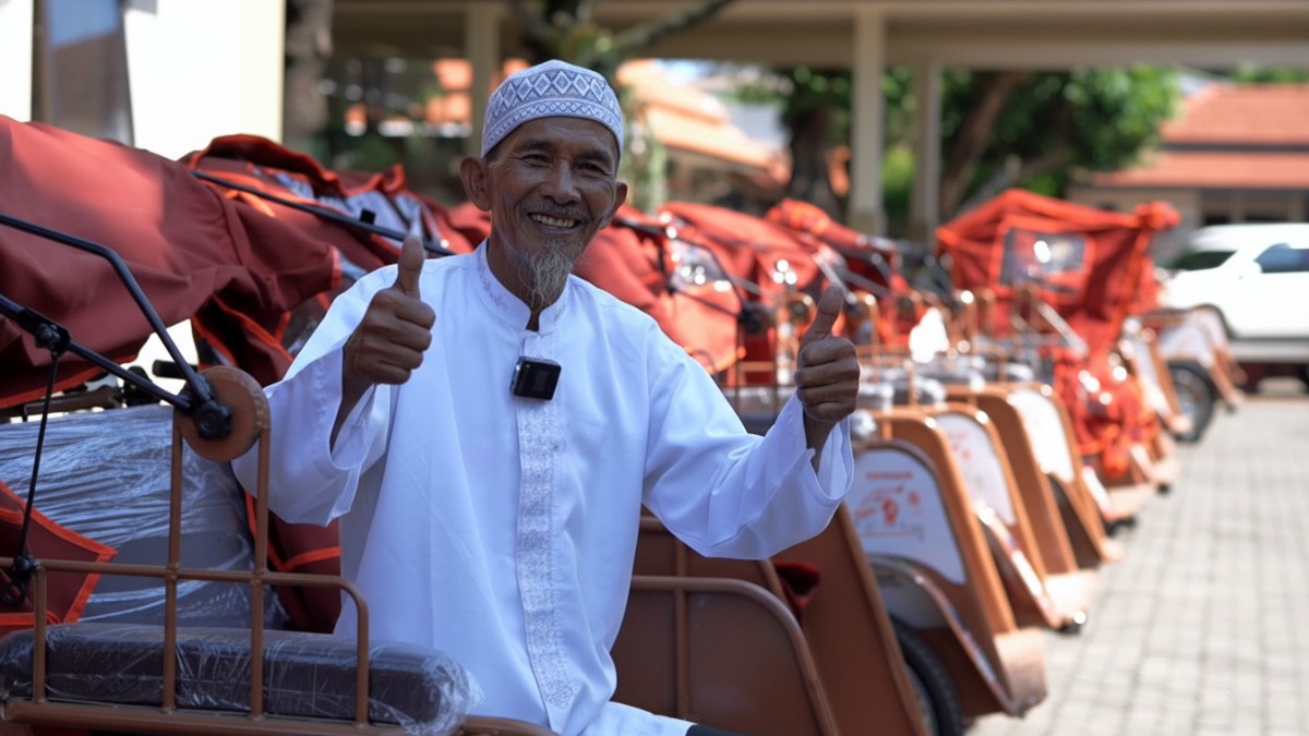 Penarik becak lansia menerima becak listrik gratis di Pendopo Lokatantra Lamongan dengan wajah lega dan penuh harapan.