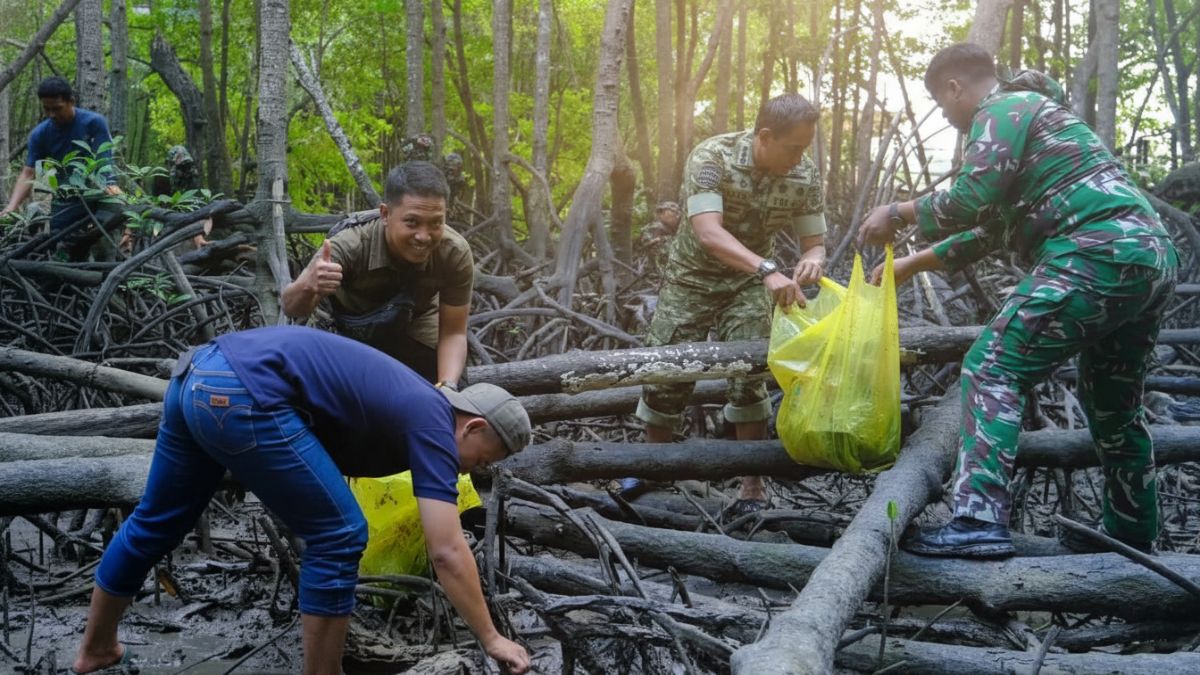 Personel TNI melakukan gotong royong membersihkan kawasan wisata Mangrove Somber Balikpapan
