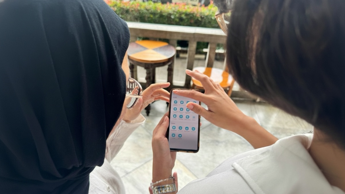 Ilustrasi warga mengakses aplikasi PLN Mobile melalui ponsel untuk mendapatkan promo tambah daya listrik.