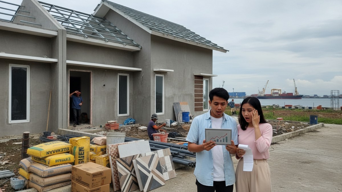 Proses renovasi rumah sederhana di Balikpapan dengan pekerja dan material tertata.