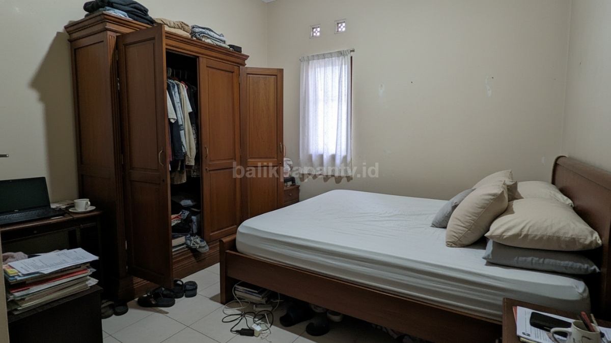 Contoh kamar sempit yang salah penataan, tempat tidur terlalu besar dan lemari pintu ayun terbuka menghalangi jalan