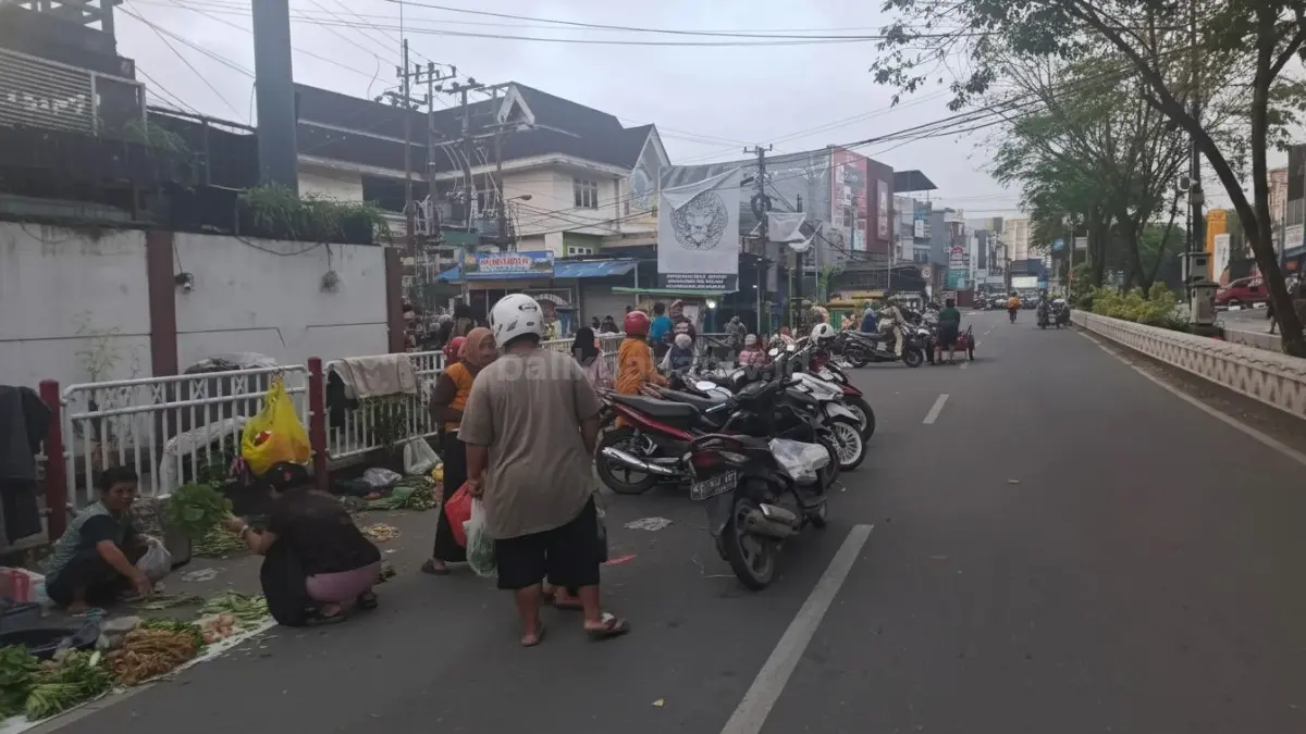 Aktivitas padat pedagang dan kendaraan di Pasar Segiri dengan parkir meluber ke bahu jalan.