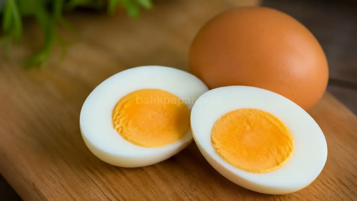 Ilustrasi telur utuh dibelah menampilkan putih dan kuning telur dengan pencahayaan natural. (BTV/Ai)