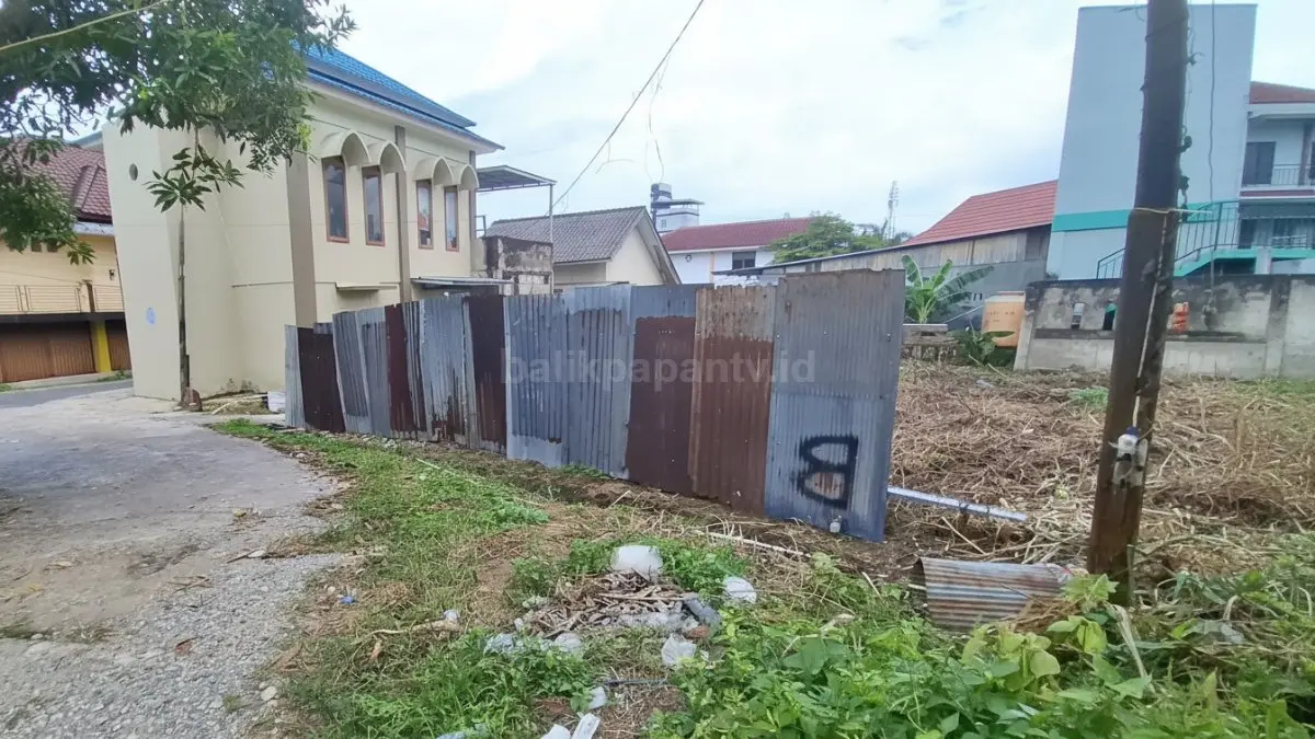 Lahan kosong dengan seng terpasang yang direncanakan jadi kos.