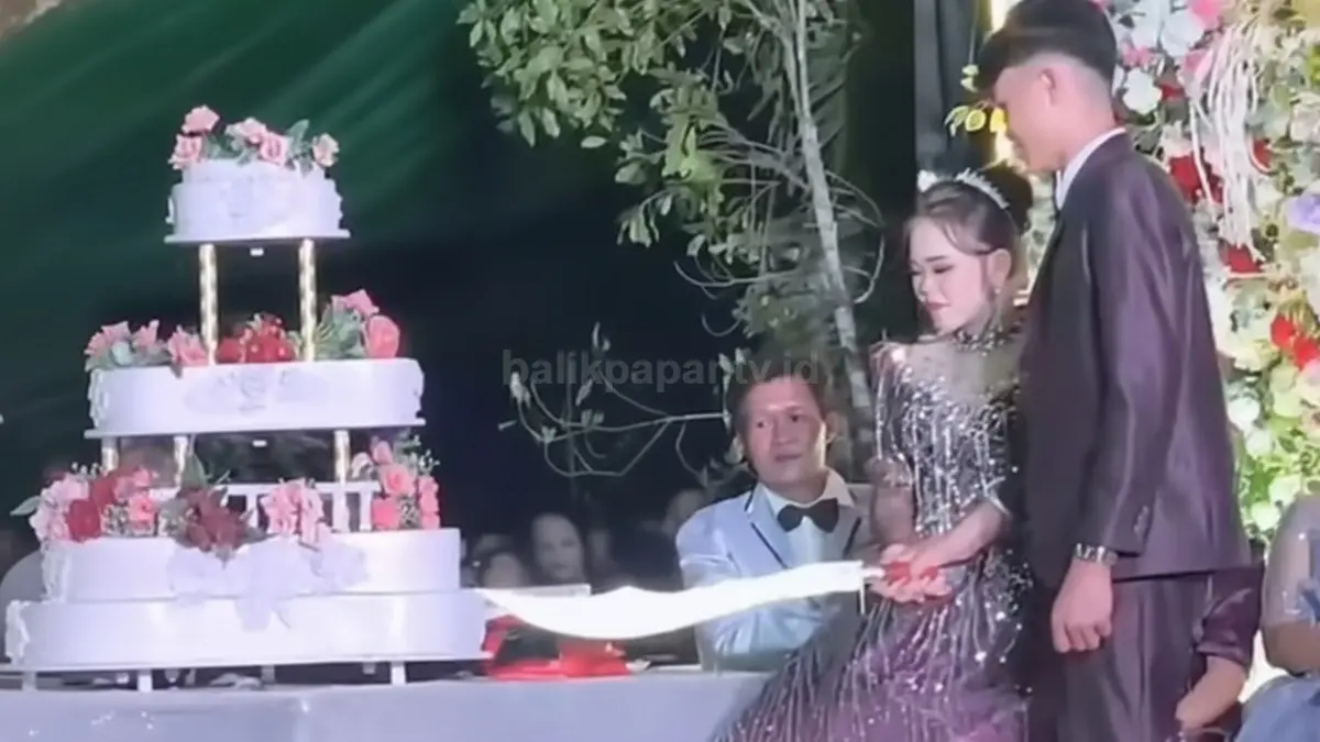 Pasangan pengantin di Minahasa Selatan memotong kue pernikahan bertingkat menggunakan pedang panjang yang viral di media sosial.