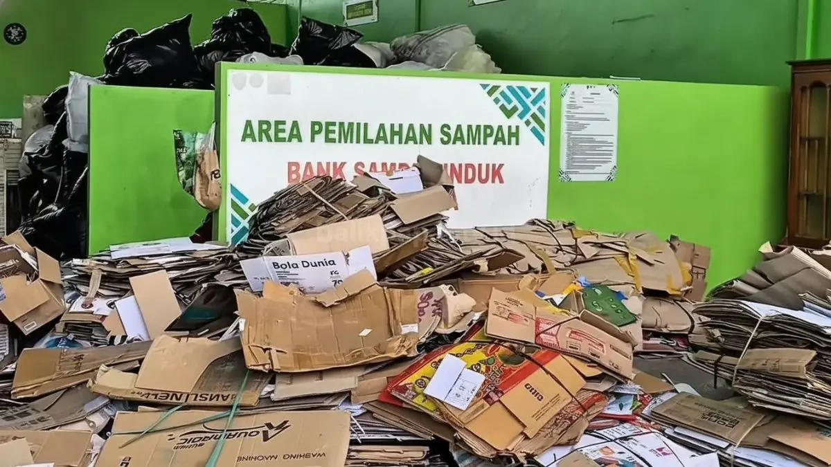 Petugas Dinas Lingkungan Hidup Kabupaten Penajam Paser Utara sedang melayani penimbangan botol plastik dan kardus milik nasabah bank sampah di fasilitas TPS3R Pasar Penajam.
