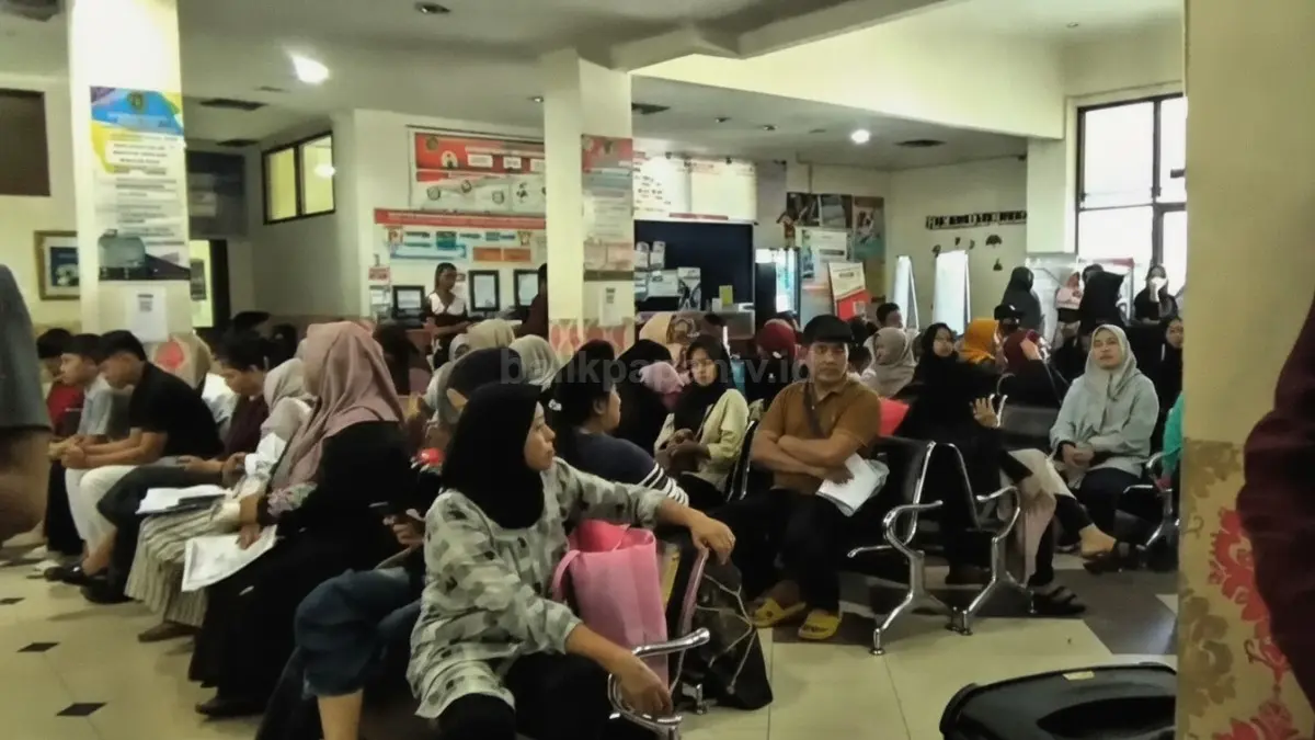 Suasana antrean padat warga dan pelajar di depan loket pelayanan Dinas Kependudukan dan Pencatatan Sipil Kabupaten Penajam Paser Utara saat musim liburan sekolah.