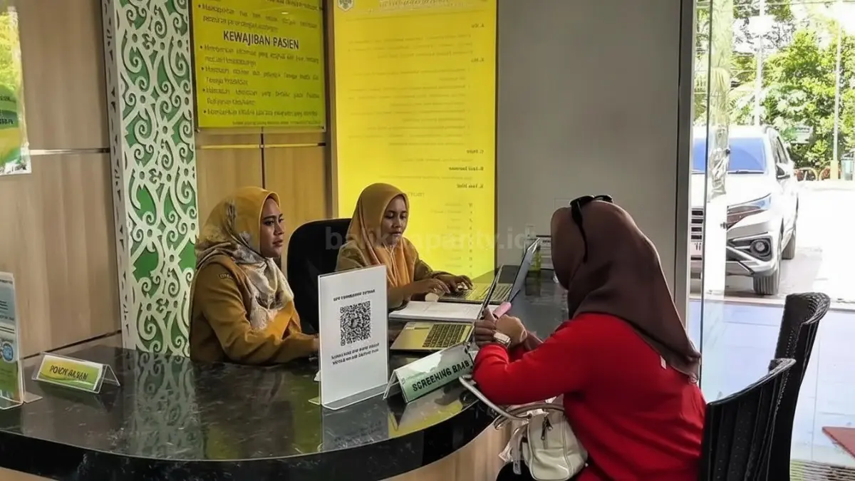 Petugas medis UPTD Puskesmas Petung sedang memberikan panduan pengoperasian aplikasi Mobile JKN kepada warga di ruang tunggu pelayanan.