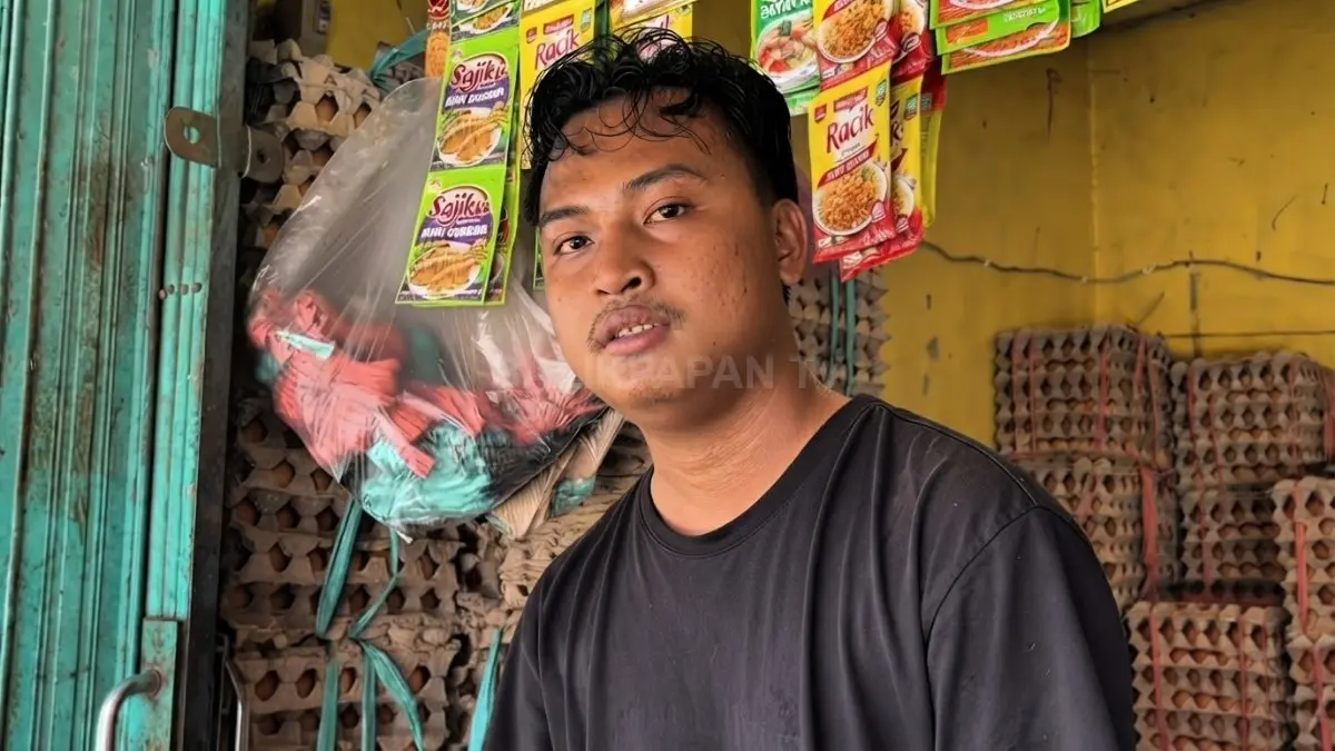 Pedagang Pasar Petung menunjukkan harga grosir telur enam piring per ikat dengan variasi sesuai ukuran. (BTV/AI)