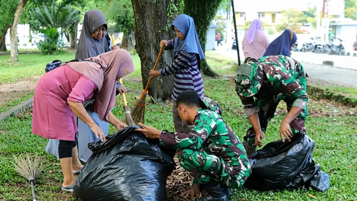Prajurit TNI, warga, dan DLH bergotong royong membersihkan Lapangan Merdeka Balikpapan pada HUT ke-68 Kodam VI/Mulawarman.