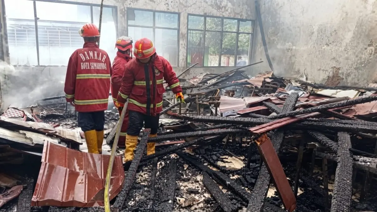 Petugas memadamkan kebakaran yang menghanguskan lima ruang kelas SDN 002 Loa Janan di Kutai Kartanegara.