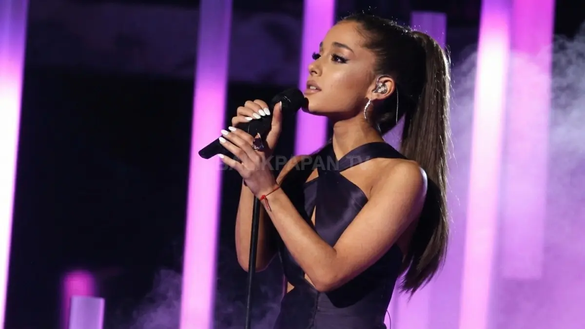 Ariana Grande sedang menyanyi di atas panggung dengan pencahayaan panggung emosional yang megah. (BTV/Ai)
