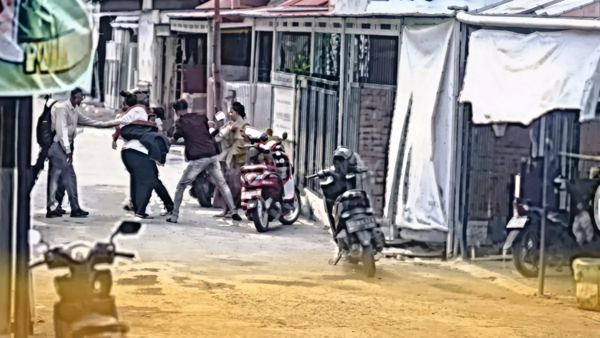 Tangkapan layar rekaman kamera pengawas (CCTV) memperlihatkan sekelompok warga dan sepeda motor berkumpul di jalan permukiman Balikpapan Timur tempat pengeroyokan terjadi.