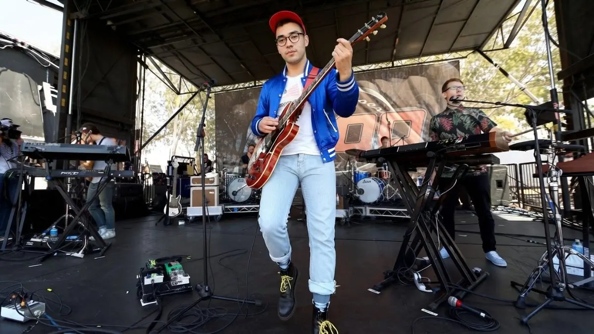 Jack Antonoff saat tampil di panggung konser, menggambarkan perjalanan band dari proyek pribadi menjadi grup enam personel.
