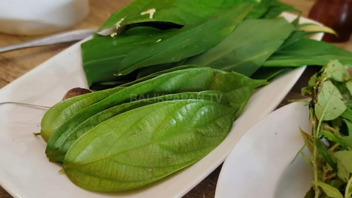 Proses memasak hidangan khas Kalimantan Timur menggunakan daun hutan untuk memperkaya aroma dan cita rasa. (BTV/AI)