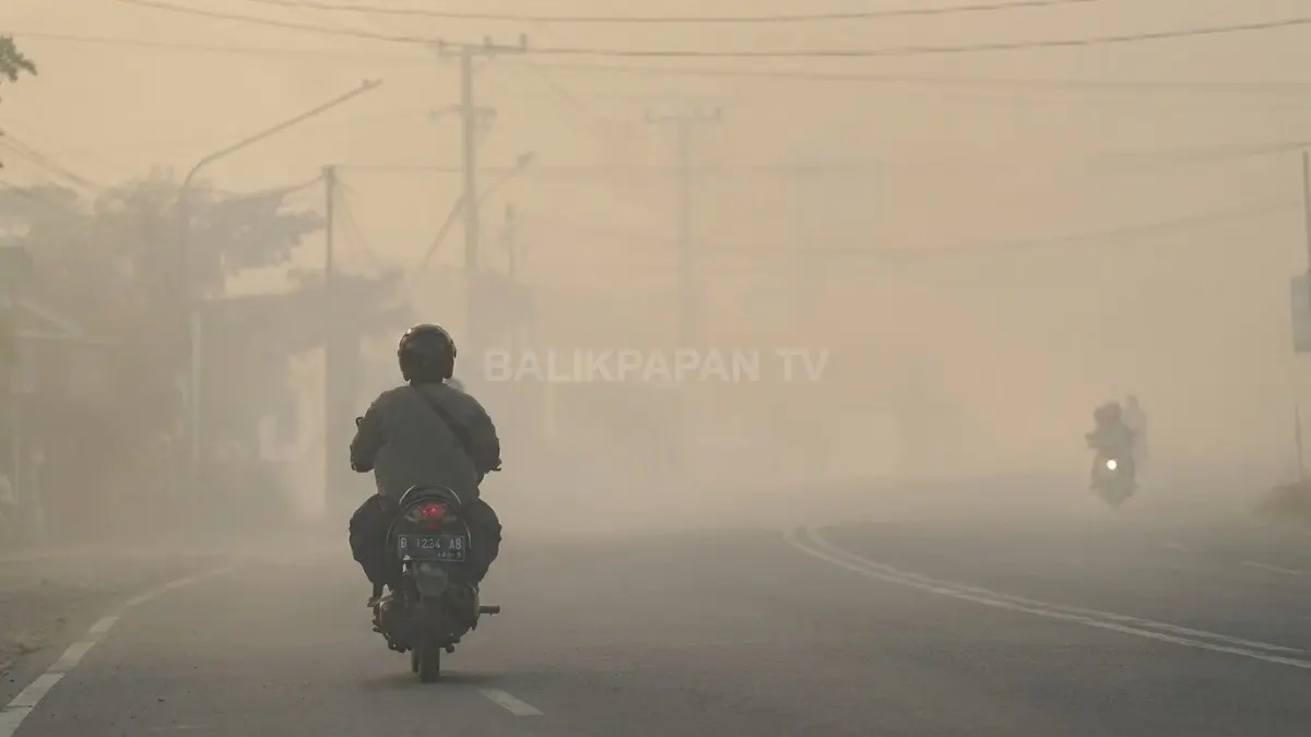 Kabut asap karhutla menyelimuti jalan di Banjarbaru dan membatasi jarak pandang pengguna jalan.