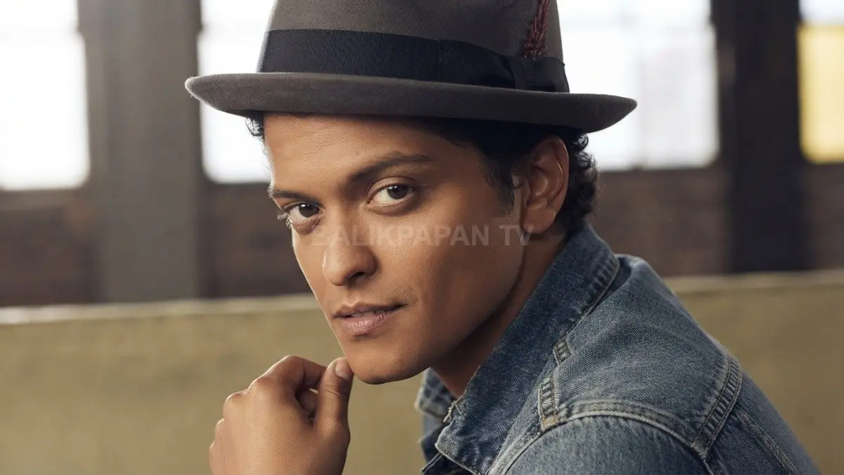 Penampilan ikonik Bruno Mars mengenakan topi fedora dan jaket denim yang sarat gaya kharismatik. (BTV/Ai)