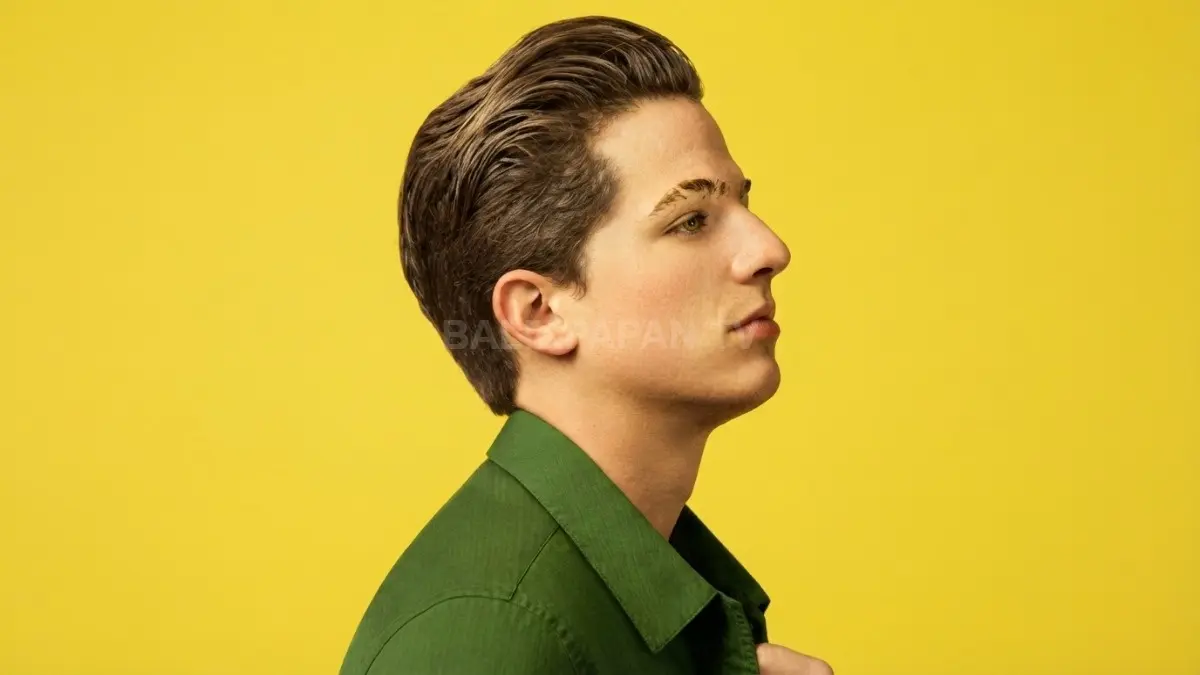 Potret musisi Charlie Puth dari samping dalam balutan kemeja hijau berlatar kuning yang memikat. (BTV/Ai)