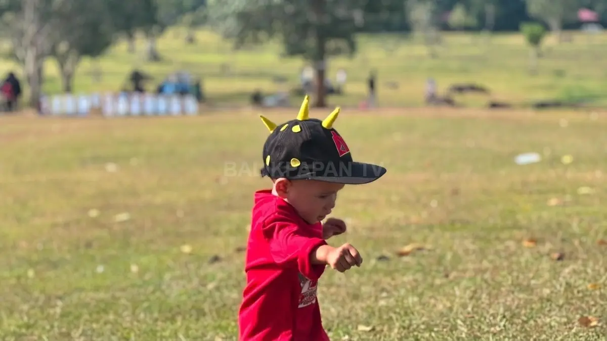 Seorang anak mengenakan topi BoBoiBoy sambil bermain ceria menikmati suasana hijau di kawasan Bukit Kebo. (AHLA/BTV)