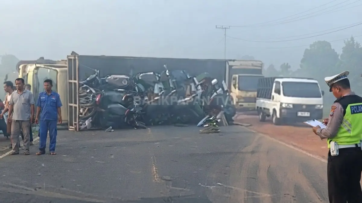 Truk pengangkut puluhan motor Honda terbalik setelah terlibat kecelakaan di tengah kabut asap tebal yang menyelimuti wilayah Kabupaten Banjar, Kalimantan Selatan, Rabu (19/8/2026).