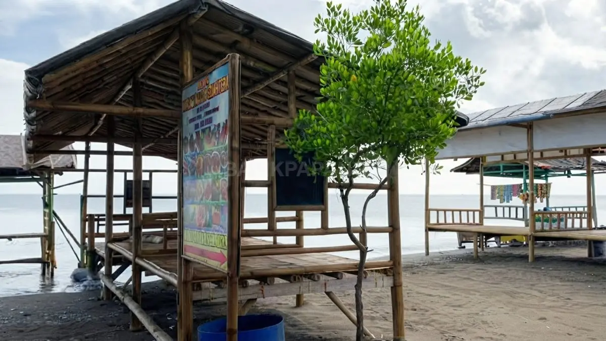 Gazebo di tepi Pantai Pelangi menjadi tempat keluarga beristirahat setelah bermain air.